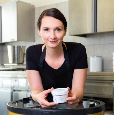 Eisspezerei - Inhaberin Alexandra Banitsch lächelt freundlich mit einem ihrer Eisbecher in die Kamera